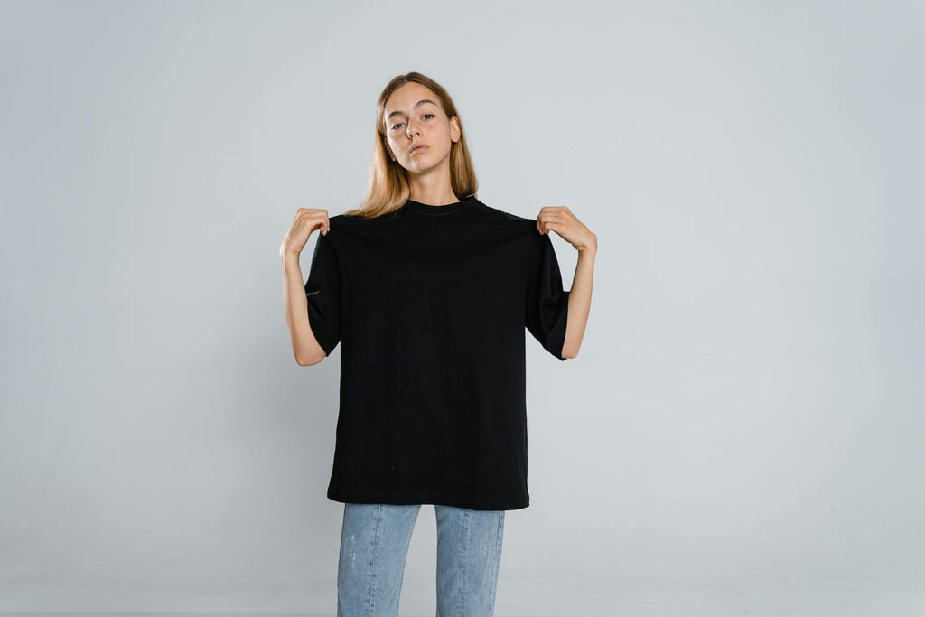 Person wearing a black t-shirt on a plain background
