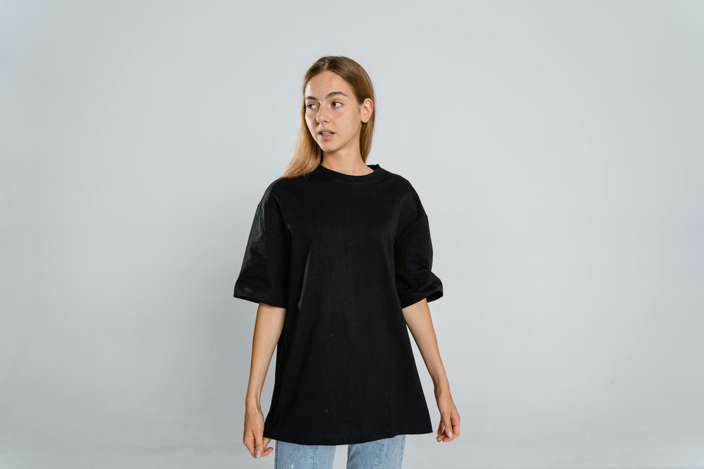 Woman wearing a black oversized t-shirt on a gray background